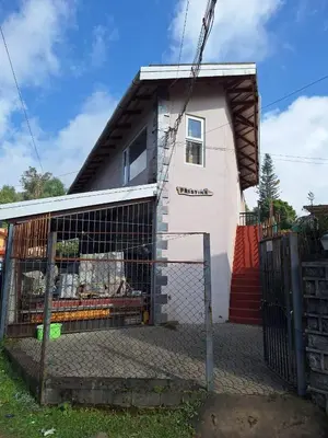 a house with a fence in front of it at Pristine Stay by LexStays in Coonoor