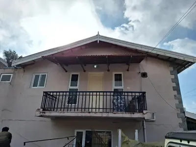 a house with a balcony on top of it at Pristine Stay by LexStays in Coonoor