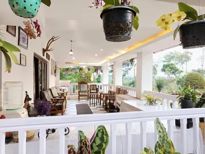 a living room with potted plants on the stairs at The Blue Mountains Estate Stay in Madikeri