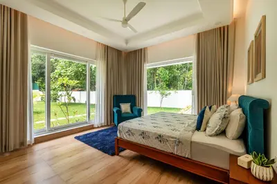 a bedroom with a bed and a large window at Le Jardin - Luxury Private Pool Villa near Kochi, Kerala in Ernakulam