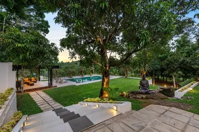 a person sitting under a tree in a park at Le Jardin - Luxury Private Pool Villa near Kochi, Kerala in Ernakulam