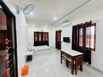 a room with a table and a bed in it at Aagneyam mansion in Kozhikode