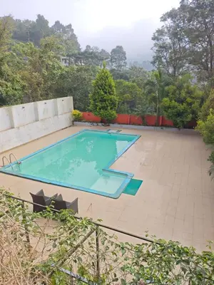 a swimming pool in the middle of a yard at GIRASSOL the hill villa in Vythiri