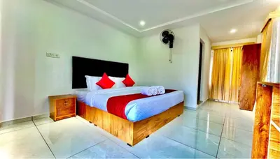 a bedroom with a large bed with red pillows at Brighton Stays in Sultan Bathery
