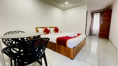 a bedroom with a bed and a table and a chair at Brighton Stays in Sultan Bathery