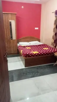 a bed in a room with a red wall at Sri Sapthagiri comfort in Mysore