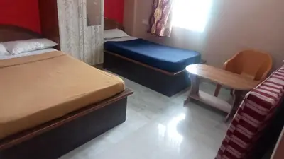a small bedroom with two beds and a chair at Sri Sapthagiri comfort in Mysore