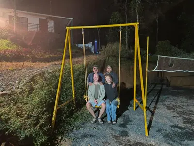 a group of people sitting on a swing at LilliputHaven Treehut in Sultan Bathery