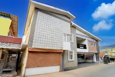 a building with a garage door and a building at Super Collection O Charing Cross Ooty in Ooty