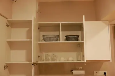 a kitchen with white cabinets with bowls and dishes at Luxairy in Chewarra