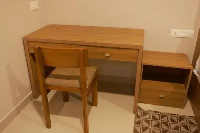 a wooden desk with a chair next to a table at Luxairy in Chewarra
