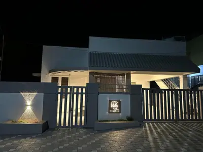 a white house with a gate and a fireplace at Vels Villa A home away from home at Pollachi in Pollāchi