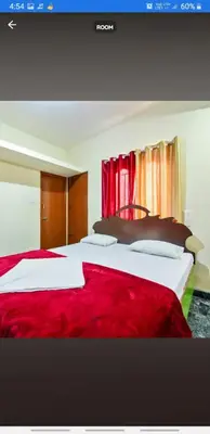 a hotel room with two beds with red sheets at Sri Sai Residency Ooty in Ooty