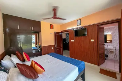a bedroom with a bed with pillows and a television at Stella Marries Airpot Lounge in Nedumbassery