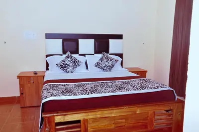 a bed with two pillows on it in a room at Palm Resort in Gūdalūr