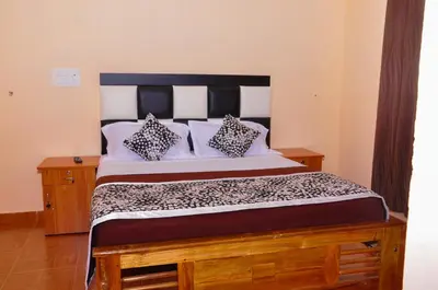 a bedroom with a large bed with two pillows at Palm Resort in Gūdalūr