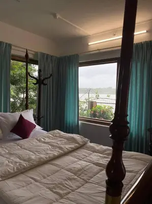 a bedroom with a bed and a large window at Kadal boutique beach stay in Green Island