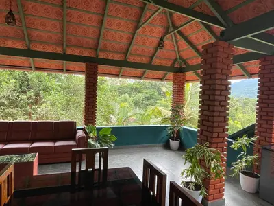 a screened in porch with a couch and chairs at CASTELLO Holiday Villa in Kalpetta