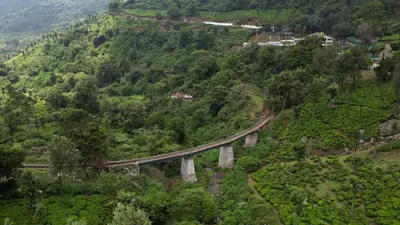 a train on a bridge on a mountain at Casa de Selas - A Chalet Stay in Coonoor