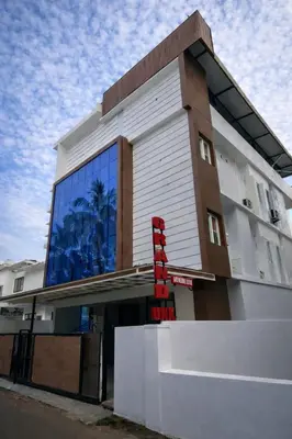 a building with a red sign in front of it at Grand UNX in Kannur