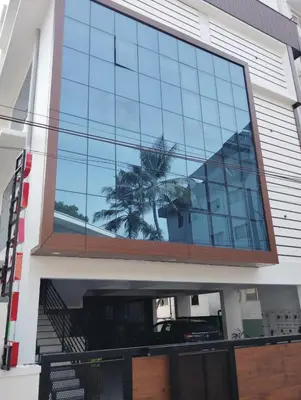 a reflection of a palm tree in the windows of a building at Grand UNX in Kannur