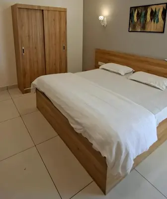 a bedroom with a large bed with white sheets at Grand UNX in Kannur