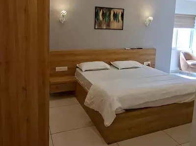 a bedroom with a large bed with white sheets at Grand UNX in Kannur