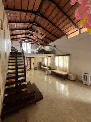 a large room with a staircase and a couch at Aaloka stay in Mysore