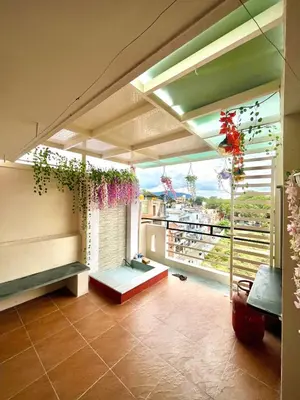 a living room with a large window with plants at Aaloka stay in Mysore