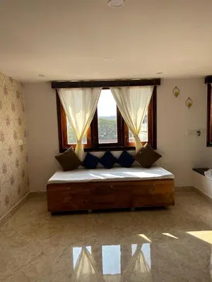 a bedroom with a large bed with a window at Aaloka stay in Mysore