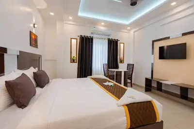 a hotel room with a large bed and a television at Cochin Airport Hotel in Ernakulam