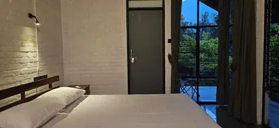 a bedroom with a bed and a door leading to a balcony at Pannadikadu Homestay in Sethumadai