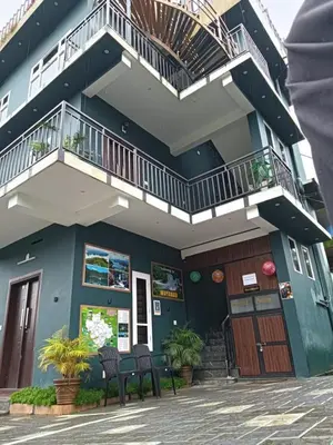a blue building with two chairs and a balcony at Tea vista holiday home in Kalpetta