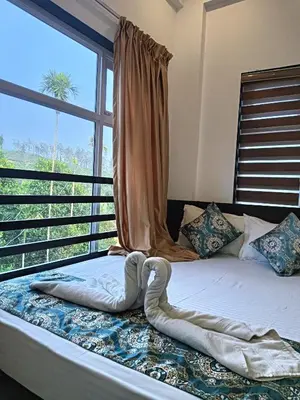 a bed in a room with a large window at Tea vista holiday home in Kalpetta