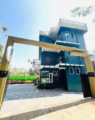 a blue building with a balcony on top of it at Tea vista holiday home in Kalpetta