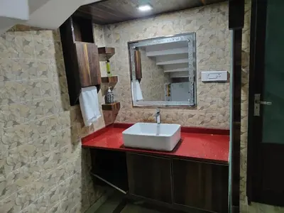 a bathroom with a white sink and a mirror at Stay Easy - Potta, Athirapally Road in Kizhake Chālakudi