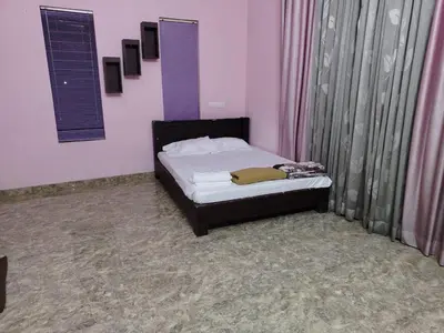 a small bed in a room with pink walls at Stay Easy - Potta, Athirapally Road in Kizhake Chālakudi