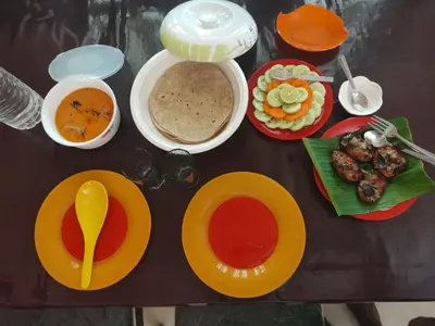 a table with plates of food and bowls of soup at Katadi beach home in Thanniyam