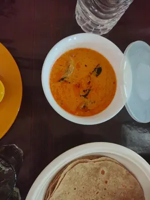 a table with a bowl of soup and a plate of food at Katadi beach home in Thanniyam