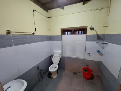 a bathroom with a toilet and a sink at VIHA The Heaven in Meppādi