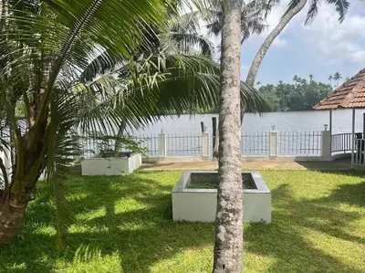 a palm tree sitting next to a body of water at RiverSoul Villa in North Paravur