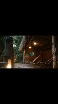 a building with a thatched roof and a stove at HeavensAway in Marayoor