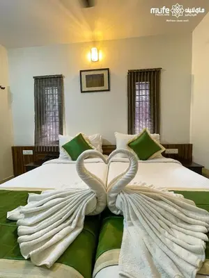 two swans making a heart on a bed at Milife Medicity Perashannoor in Kuttippuram