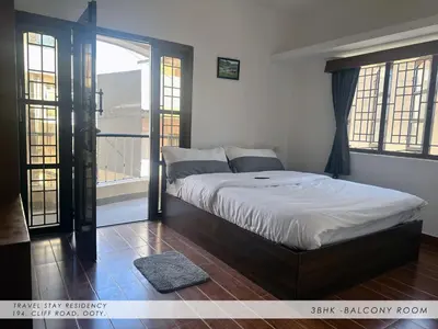 a bedroom with a bed and a large window at Travel & Stay in Ooty