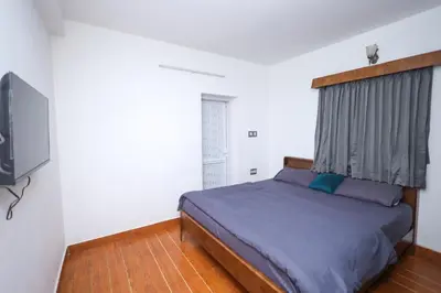 a bedroom with a bed and a flat screen tv at Travel & Stay in Ooty