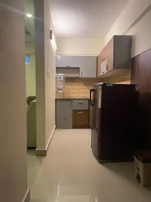 a kitchen with a black refrigerator in a room at VVP Rooms in Cochin