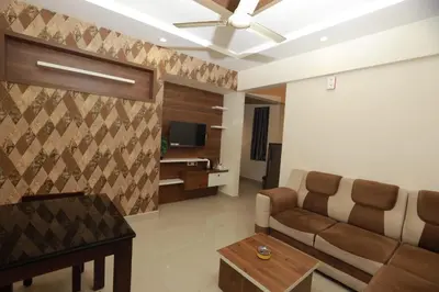 a living room with a couch and a tv at VVP Rooms in Cochin