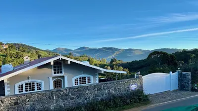 a house with a stone wall and a fence at Jade Pearl Kotagiri in Kotagiri
