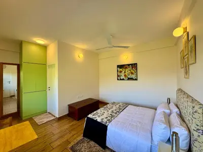 a bedroom with a bed and a green door at Jade Pearl Kotagiri in Kotagiri