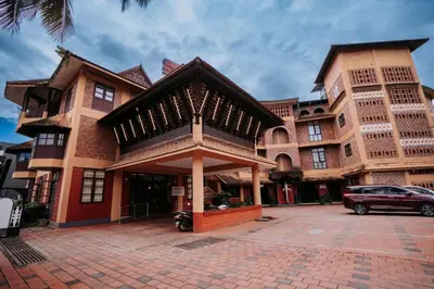 a building with a car parked in front of it at Nirmallyam Residency Hotel in Edappāl